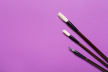 Calligraphic brushes on purple background