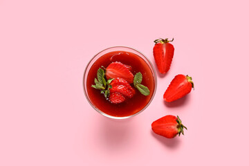 Glass with tasty strawberry panna cotta on pink background