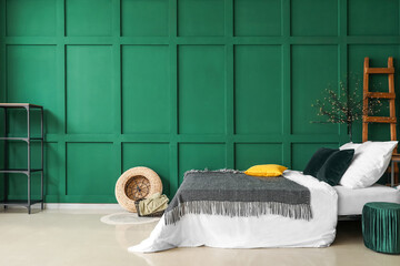 Interior of green bedroom with comfy bed and modern decor