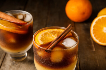 Glasses of tasty coffee with orange juice on wooden background, closeup
