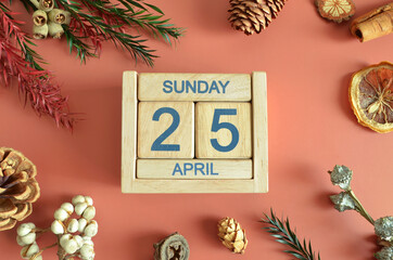 April 25, Cover design with calendar cube, pine cones and dried fruit in the natural concept.
