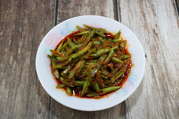Traditional spicy fried string bean with red curry serving on the plate. Famous vegetarian menu in Asia restaurant. 