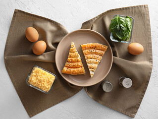 Composition with slices of tasty spinach pie on light background