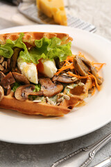Delicious Belgian waffles with vegetables in plate on table, closeup