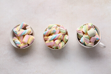 Bowls with sweet marshmallows on light background