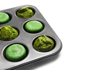 Obraz na płótnie Canvas Baking tin with tasty spinach muffins on white background, closeup