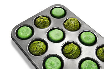 Baking tin with tasty spinach muffins on white background, closeup