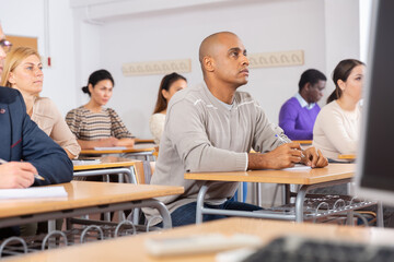 Small group of students attentively listening to lecture in classroom