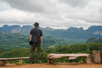 Fototapeta na wymiar man relax after hiking to top of mountain in raining season travel
