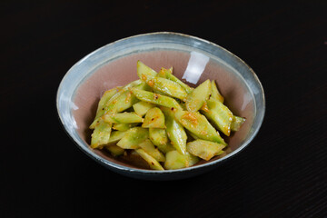 Salad with chopped cucumbers in garlic sauce on a black background