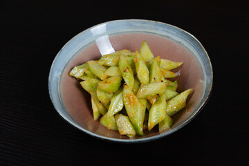 Salad with chopped cucumbers in garlic sauce on a black background