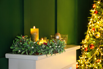 Christmas mistletoe wreath and candles on fireplace