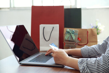 Online payment, Women hands holding credit card and using laptop for online shopping. Black Friday...