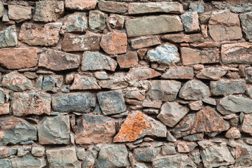 Texture of a stone wall made of natural stone with mosaic masonry for background.