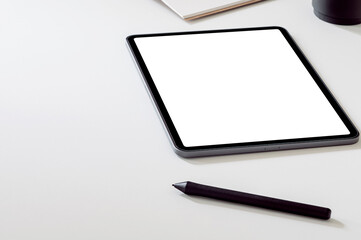 Mockup portable tablet with stylus pen on white top table.