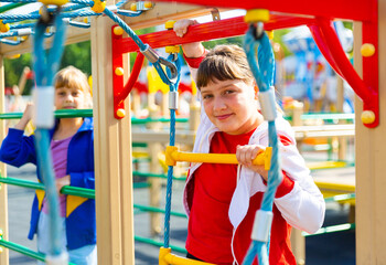 Fototapeta premium Two young girls having good time while playing on outdoor playground.