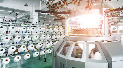 Textile industry - yarn spools on spinning machine in textile factory - obrazy, fototapety, plakaty