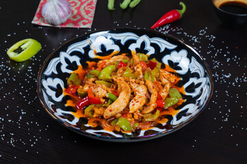 Eastern cuisine. Fried chicken with bell pepper and spices on plate