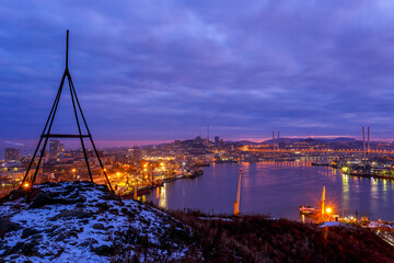 Dawn in Vladivostok. View of the Golden Horn Bay during dawn in winter. Golden bridge at sunrise.