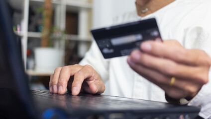 Hand of person typing on laptop and holding credit card   with  payment online banking