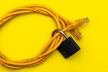 yellow internet cable twisted into a ring and a closed lock on a yellow background information...