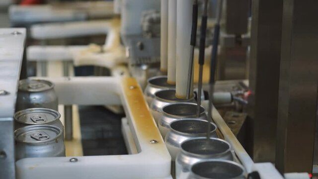 The filling cans with drinks on a production line