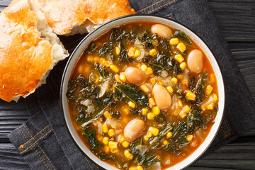 Kara lahana corbası savory cabbage soup with kale, beans and corn close-up in a bowl on the table....