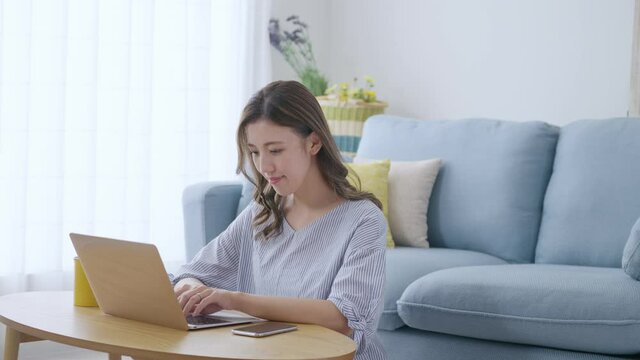 家でパソコンを操作する若い女性