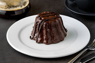 Chocolate souffle on white porcelain plate on dark stone table