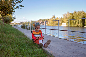 Stylish tween girl with mobile phone walking in the street, kid and gadgets, autumn lifestyle...