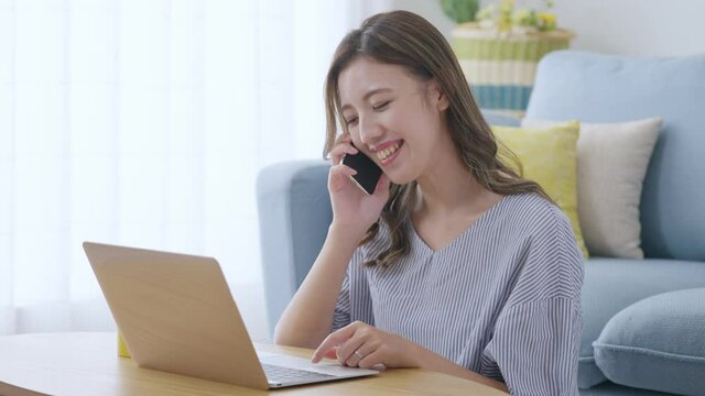 家でパソコンをしながら通話する若い女性