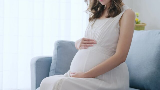 部屋でリラックスする若い妊婦	
