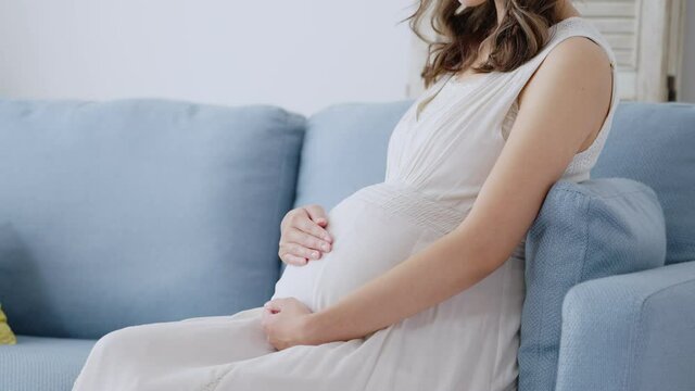 部屋でリラックスする若い妊婦	
