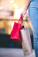 fashion shopping girl A young woman carries a colorful shopping bag as she walks along a shopping mall.