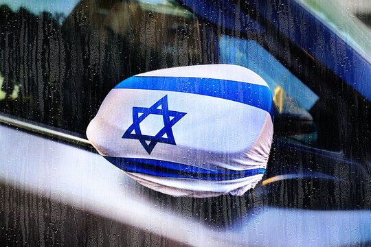 The effect of photographing through the glass of a car: rain in Israel, outside the window, rain is pouring on a neighboring car