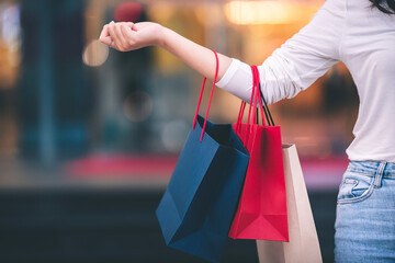 fashion shopping girl A young woman carries a colorful shopping bag as she walks along a shopping mall.