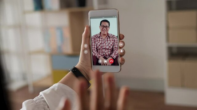 Happy woman skype chatting on smartphone with father