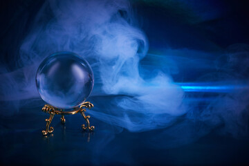 Crystal ball in a dark blue smoky background. Guessing for the future.