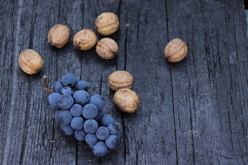 a beautiful, black-blue grape on the black, rustic wooden table