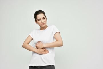 Woman in white t-shirt abdominal pain treatment for discomfort