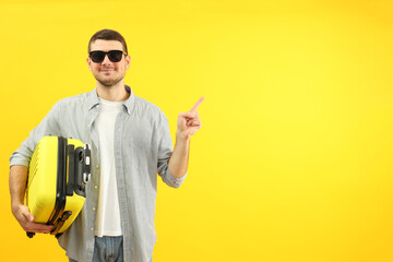 Traveling concept with young man on yellow background, space for text