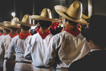 Men with traditional Mexican clothing and straw hats lining up before performance, Merida, Mexico