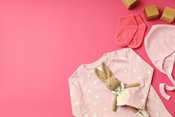 Concept of female baby clothes on pink background