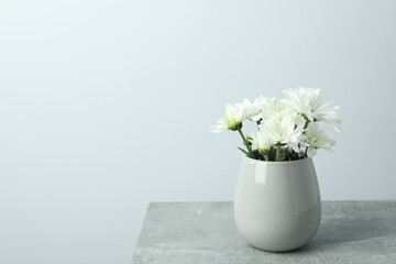 Vase with white chrysanthemums on gray textured table