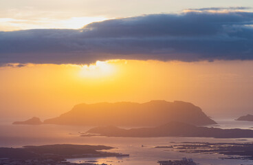 Fototapeta premium View from above, stunning sunrise during a cloudy day with the city of Olbia, the homonymous gulf and Tavolara island in the distance. Panoramic view from Monte Pino, Sardinia, Italy.