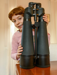 Bambina con binocolo, attrezzatura fotografia e ottica