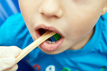 little boy brushing teeth with toothbrush closeup mouth