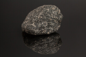 Granite stone on black background with reflection