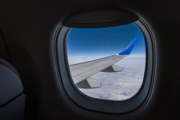 aircraft wing from the aircraft window overlooking the blue sky and beautiful clouds
