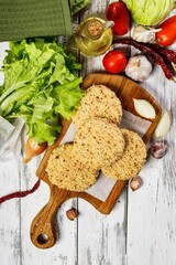 Top view chicken hamburger cutlet breaded with paprika and garlic. Homemade minced poultry cutlet with spices. Fresh lettuce leaves, tomatoes and onions. White rustic background. Copy space
